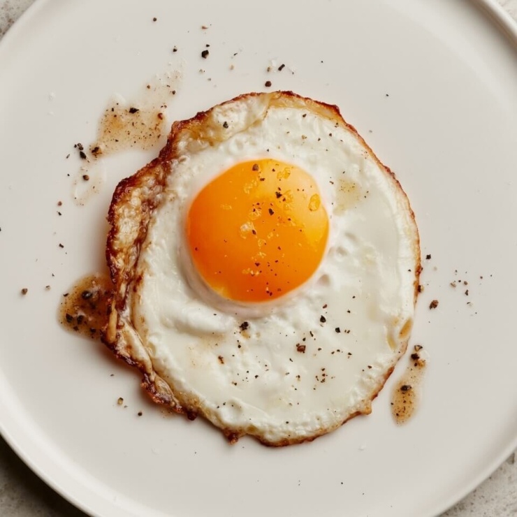 1786167364-4a46a4aa35-perfect-fried-eggs-3011-4121-3478-width740height740 Trứng giàu protein chất lượng cao, giúp tăng cảm giác no và duy trì khối cơ khi kiểm soát cân nặng, đồng thời cung cấp vitamin A, choline và các dưỡng chất hỗ trợ sức khỏe làn da. Ảnh: Elle Gourmet
