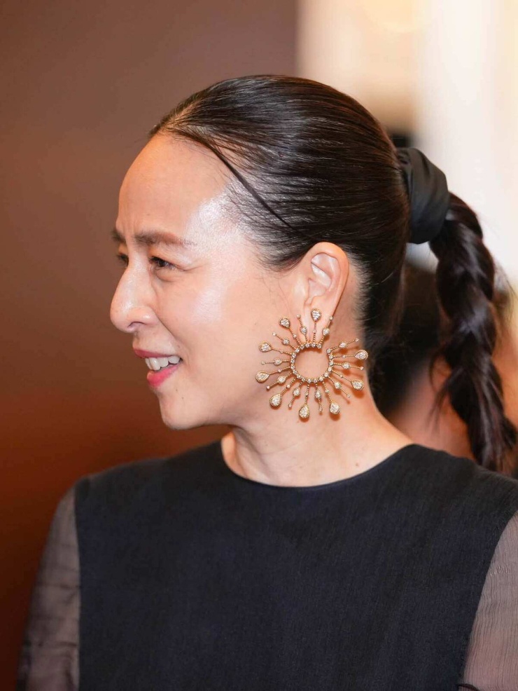 1787999237-e98073c3af-madam-pang-10-2960-2987-width740height986 Madam Pang thường xuyên sử dụng nơ trên tóc hoặc trên trang phục - một trong những bí quyết giúp bà "ăn gian" tuổi hiệu quả. Theo SCMP , nữ chủ tịch là người có gu chơi trang sức. Khác với nhiều doanh nhân thành đạt, tiểu thư tài phiệt thường sử dụng các bộ trang sức có kiểu dáng cổ điển, nhỏ nhắn, bà sưu tầm mẫu mã đa dạng, trong đó có nhiều thiết kế phá cách, bản lớn. Tạp chí Elle cho rằng cách dùng trang sức này vừa thể hiện cá tính, vừa giúp người sử dụng trông trẻ hơn.