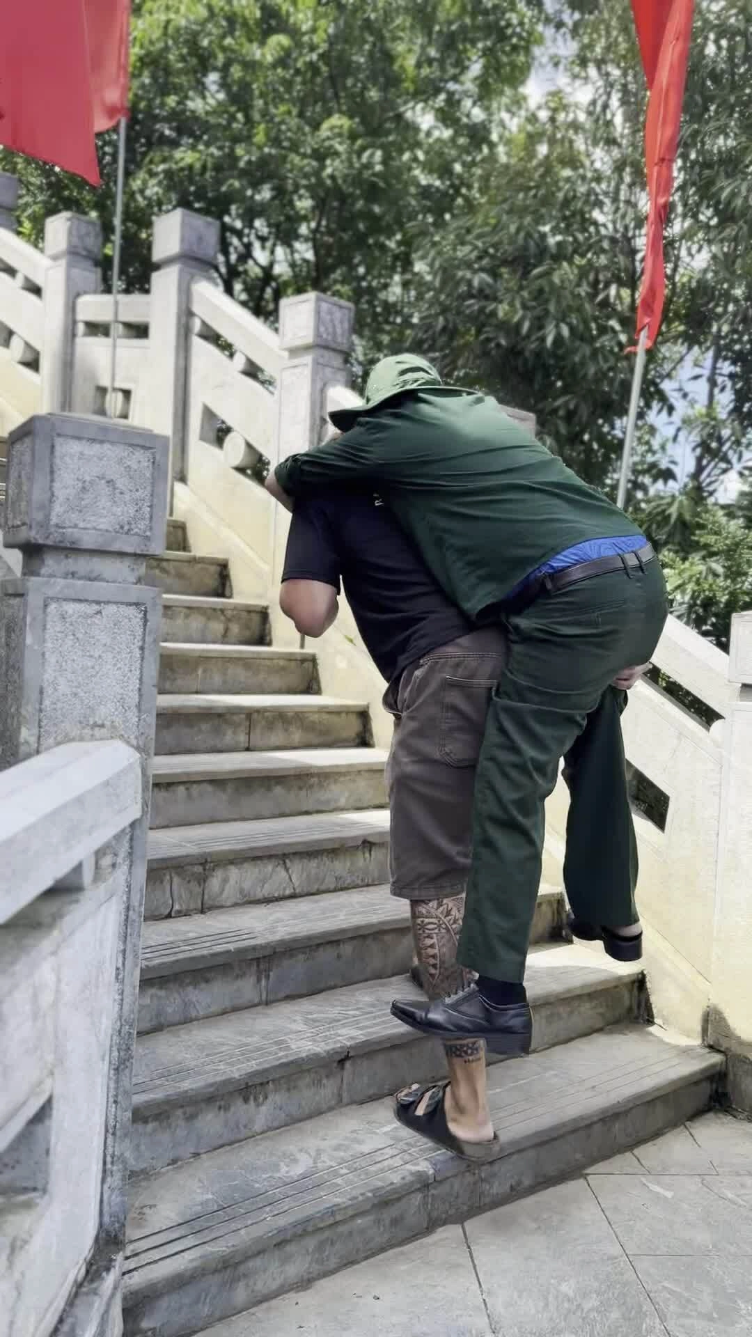 du-khach-phap-cong-cuu-chien-binh-len-dinh-cot-co-lung-cu-1786038907 Du khách Pháp cõng cựu chiến binh lên đỉnh Cột cờ Lũng Cú