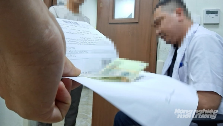 Tiền mệnh giá 100.000 đồng được kẹp trong sổ xạ trị. Ảnh: Hùng Khang/Báo Nông nghiệp và Môi trường