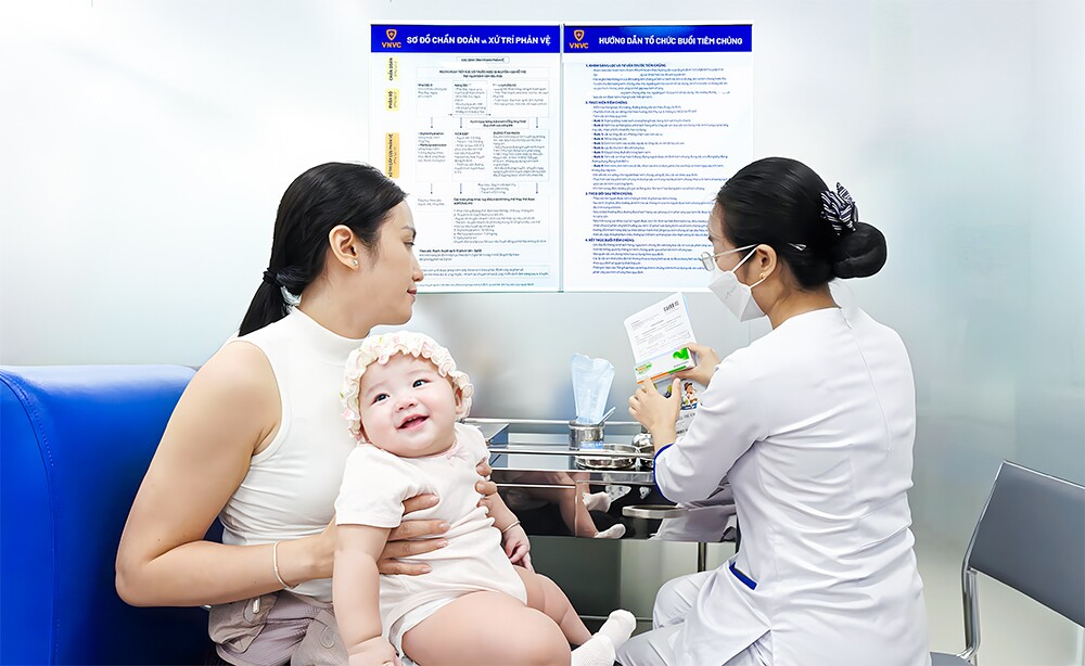 Chị Trần Thị Nga, phường Bình Đông, TPHCM đưa con gái là bé Nguyễn Trần Thiên Ý, 6 tháng tuổi đến VNVC Quận 8 tiêm vắc xin phòng tay chân miệng. Ảnh: Trung Thái