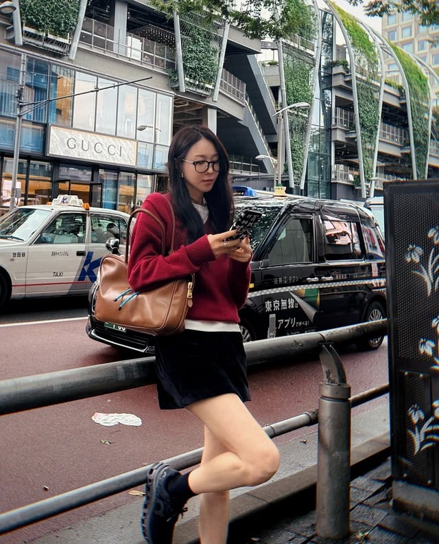 Áo len oversized kết hợp cùng chân váy da ngắn mang lại vẻ đẹp hiện đại và phóng khoáng.