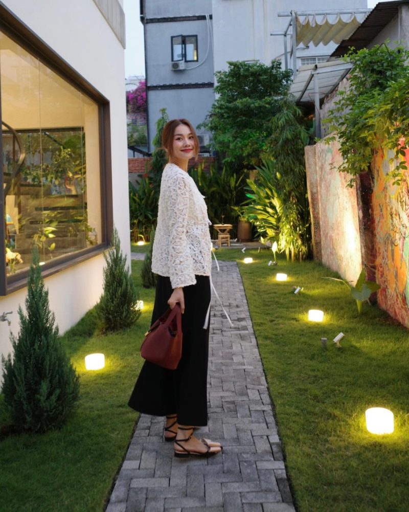 Chiếc áo ren vốn đã rất nổi bật, nên việc kết hợp với một chiếc chân váy đơn giản giúp tạo sự cân bằng cho tổng thể trang phục.