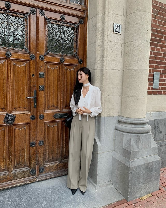 Áo blouse trắng khi mix cùng quần âu màu be giúp tạo nên diện mạo trẻ trung, nhã nhặn.