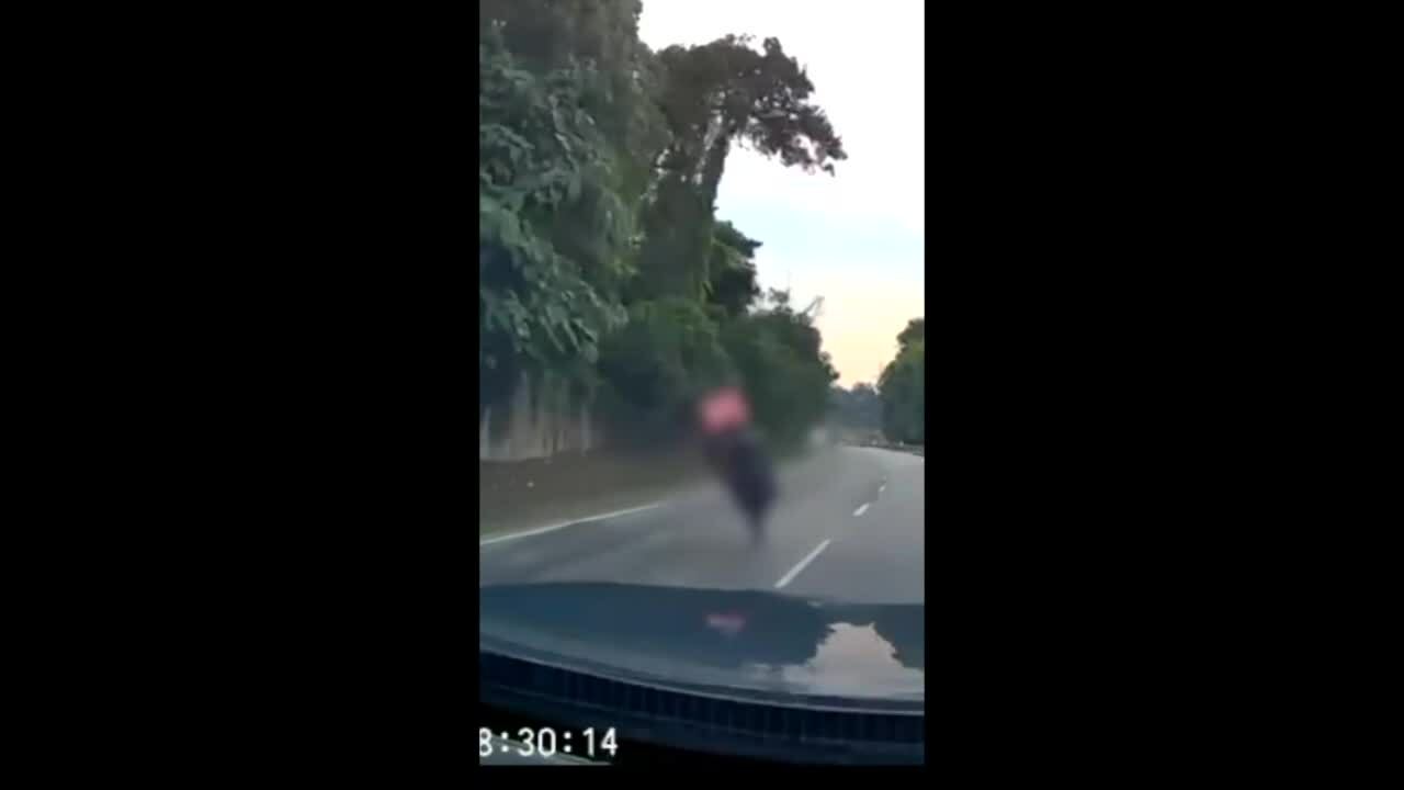 Xe máy thụt hố giữa đường ngã lộn vòng trước đầu ôtô